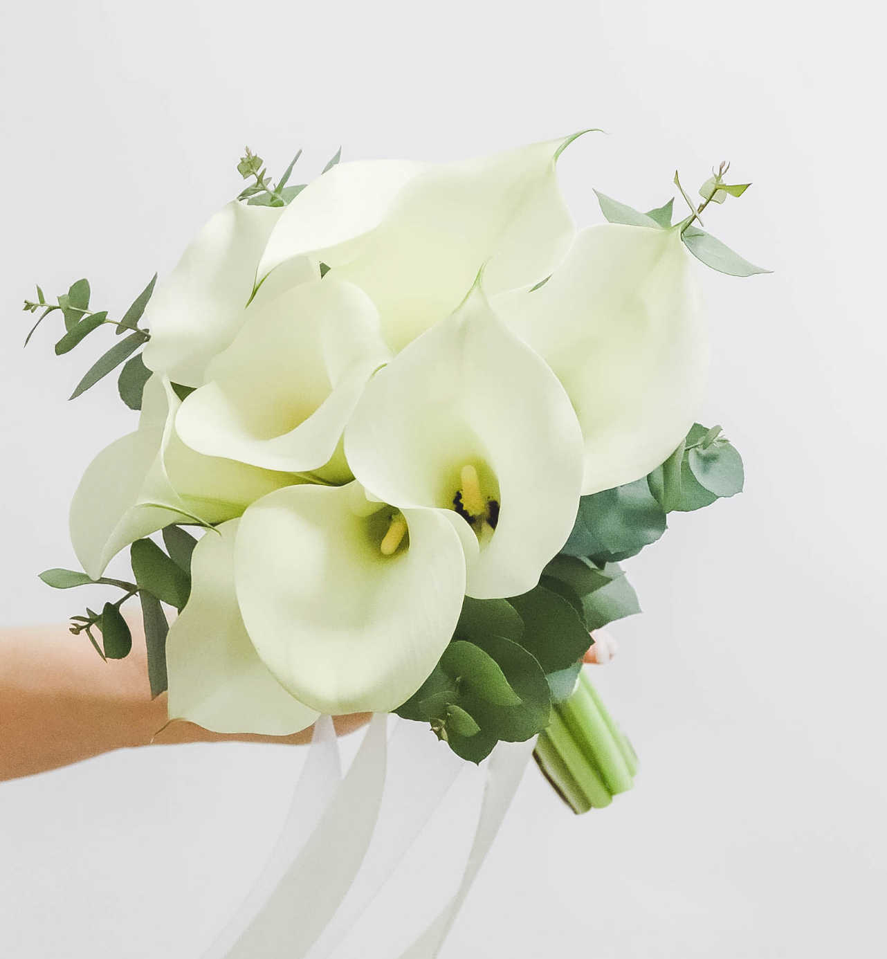 Der Brautstrauß aus Calla-Lilien und Eukalyptus in Weiß und Grün