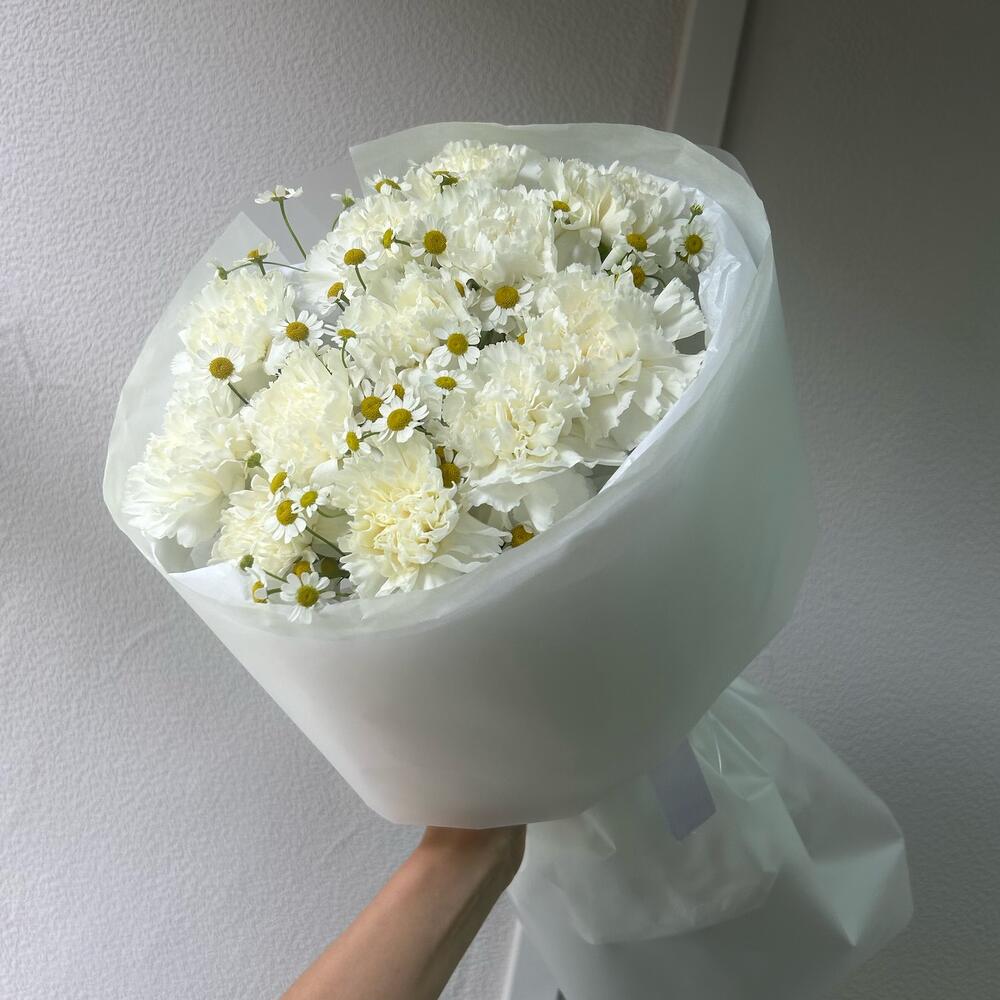 Ein Strauß aus weißen Nelken und Tanacetum