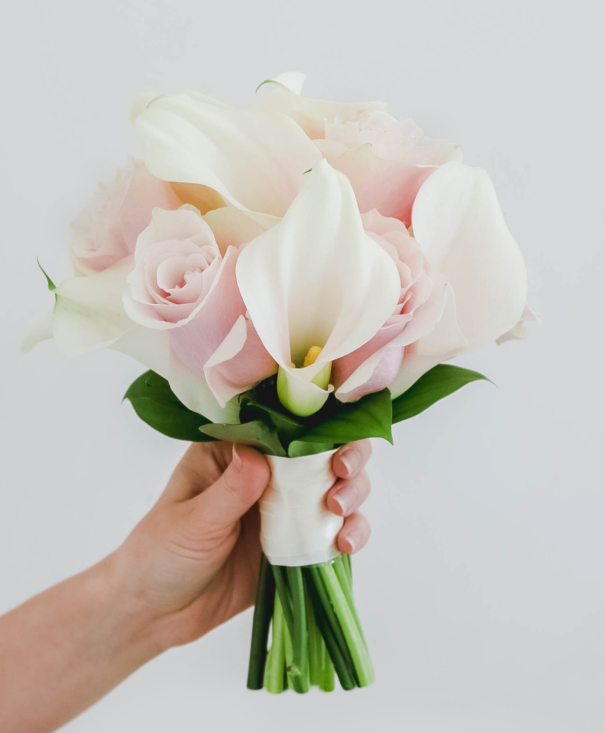 Der Brautstrauß aus Calla-Lilien und Rosen in Weiß und Rosa