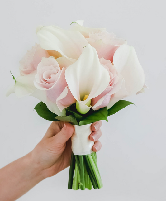 Der Brautstrauß aus Calla-Lilien und Rosen in Weiß und Rosa