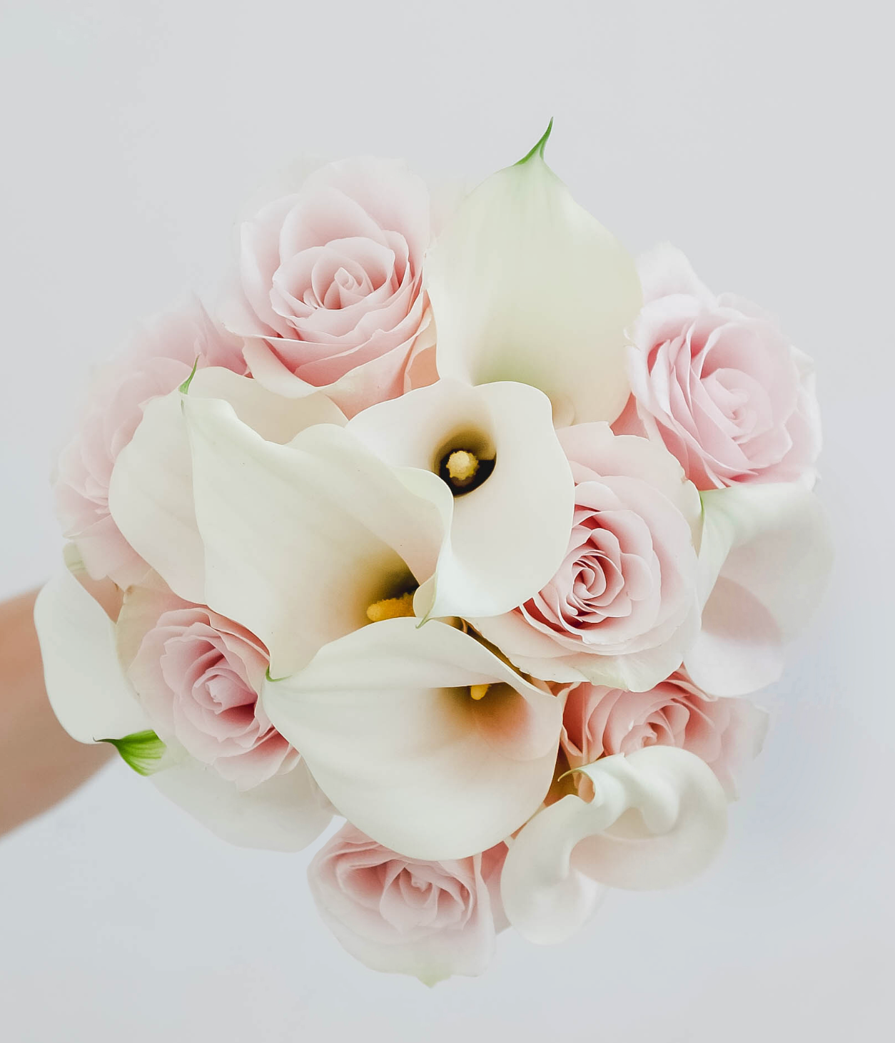 Der Brautstrauß aus Calla-Lilien und Rosen in Weiß und Rosa